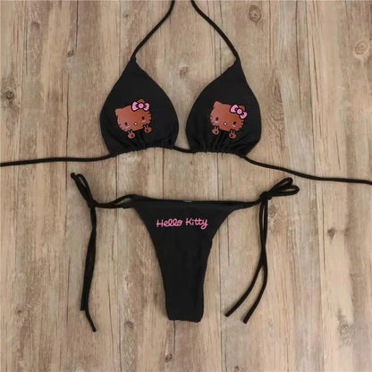 Black bikini set with Hello Kitty design on a wooden surface