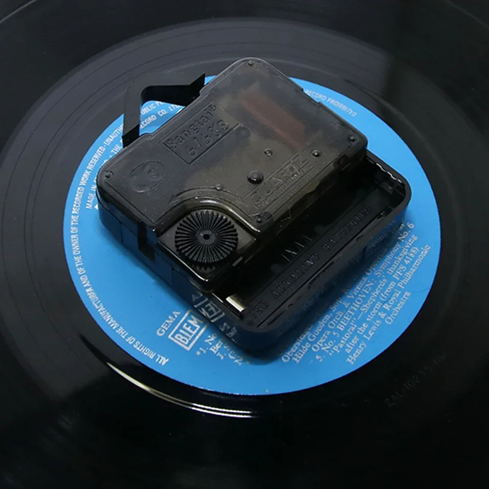 Black electronic device on a vinyl record with blue label