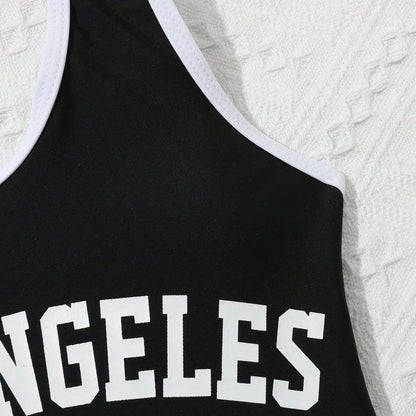 Black tank top with 'ANGELES' printed on it against a textured white background