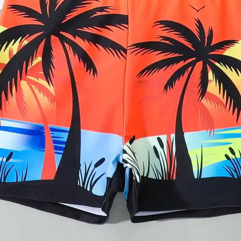 Beach-themed shorts with palm trees and sunset design on a gray background