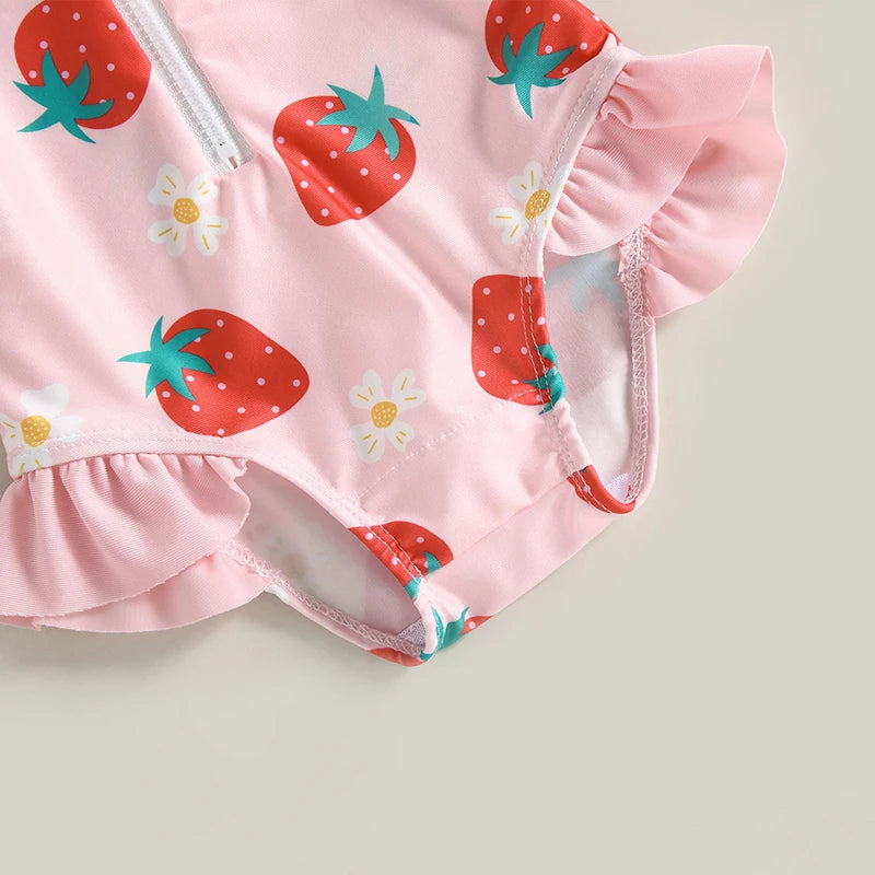 Pink children's swimsuit with strawberry pattern on a light gray background