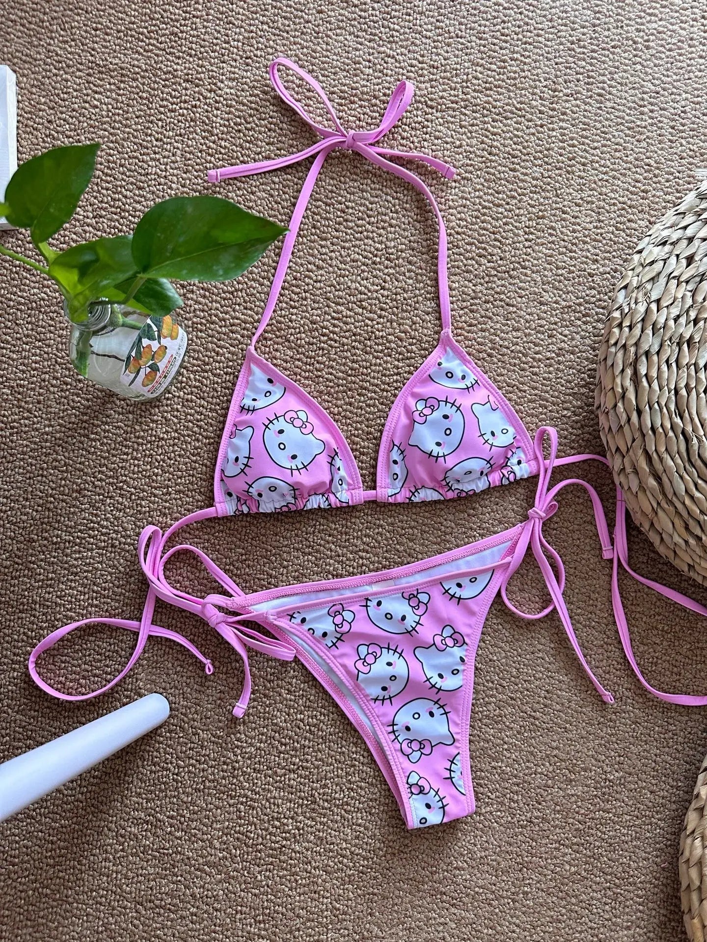 Pink bikini set with cartoon design on a brown surface