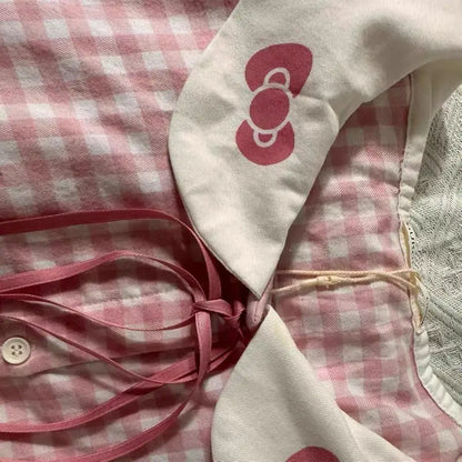Pink checkered fabric with a white bow and pink ribbon on a textured surface