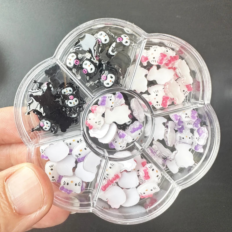 Clear plastic container with compartments filled with small cat-shaped nail art decorations.