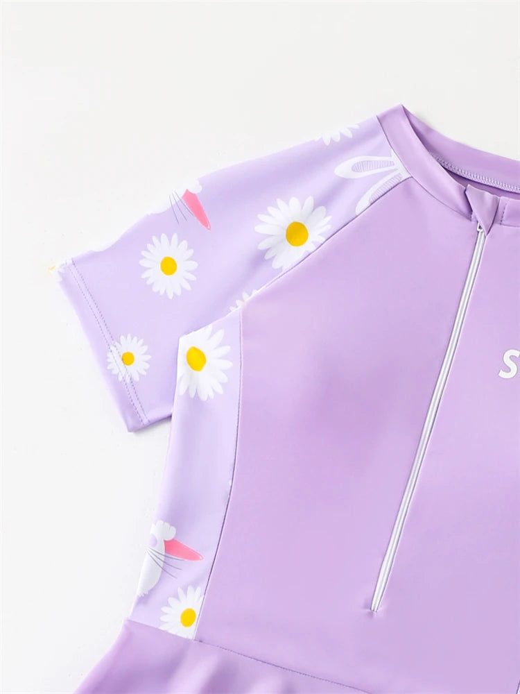 Purple children's swimsuit with daisy patterns on a white background