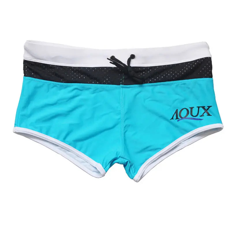 Turquoise swim shorts with black and white accents on a white background
