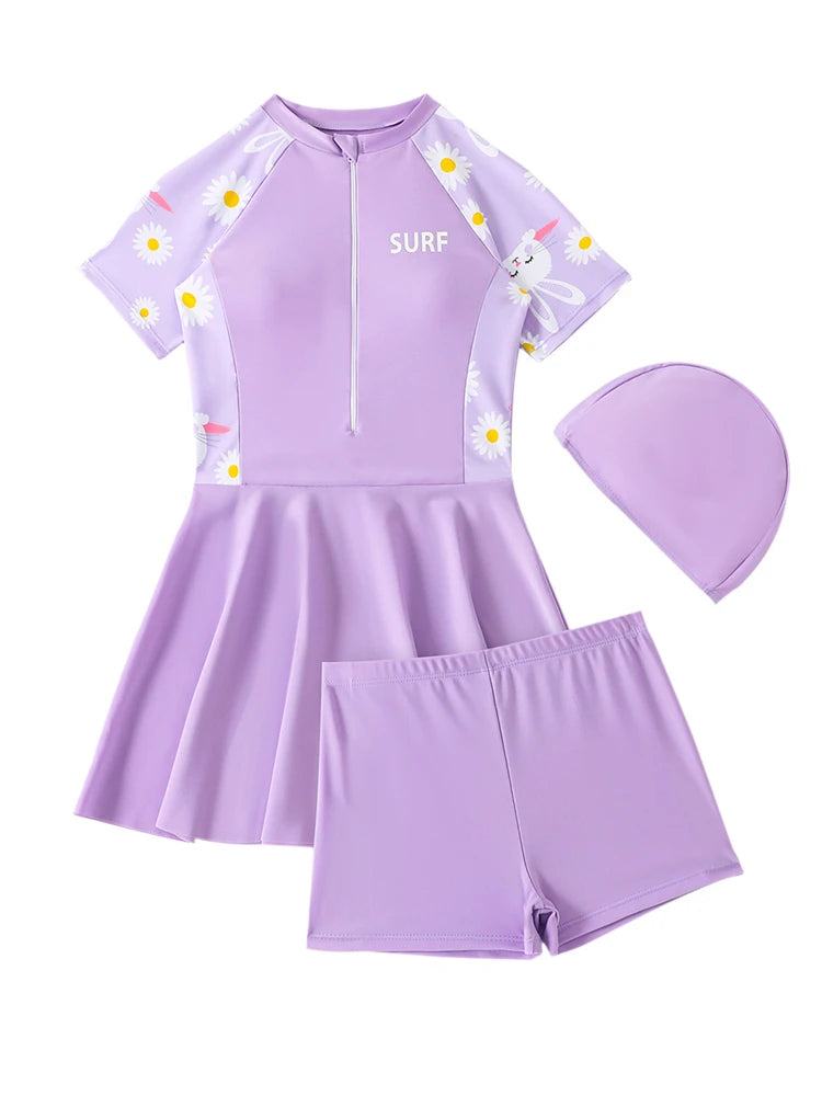 Purple children's swimsuit set with shorts, top, and cap on a white background