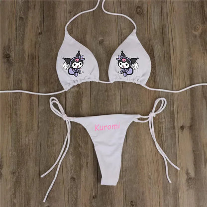 White bikini set with cartoon character and 'Kuromi' text on a wooden background
