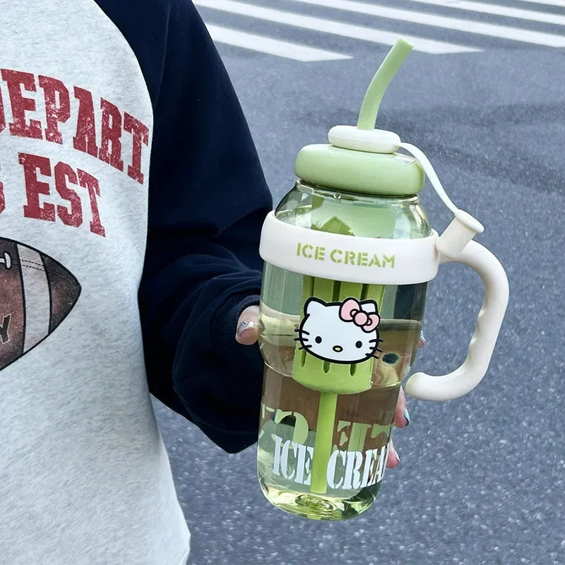Person holding a green ice cream-themed cup with a straw and handle, featuring a cartoon character.