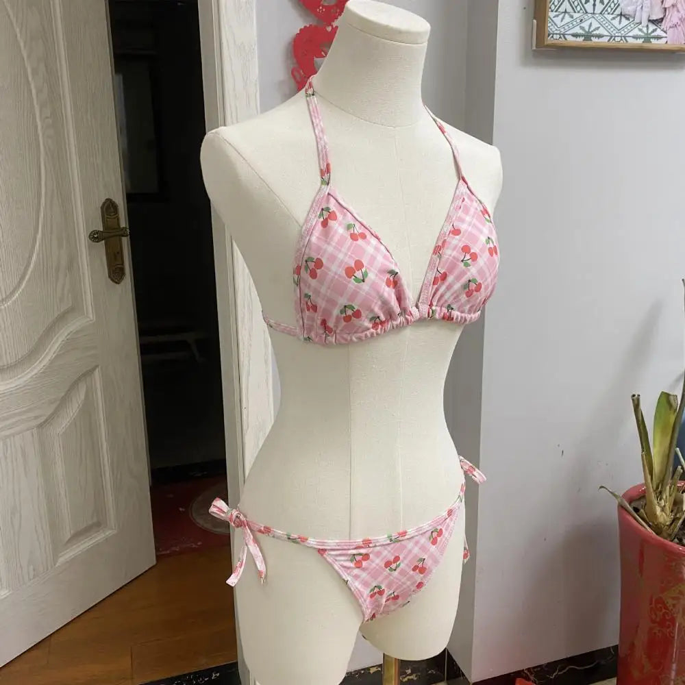 Pink bikini set on a mannequin against a white wall.