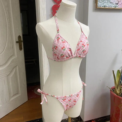 Pink bikini set on a mannequin against a white wall.