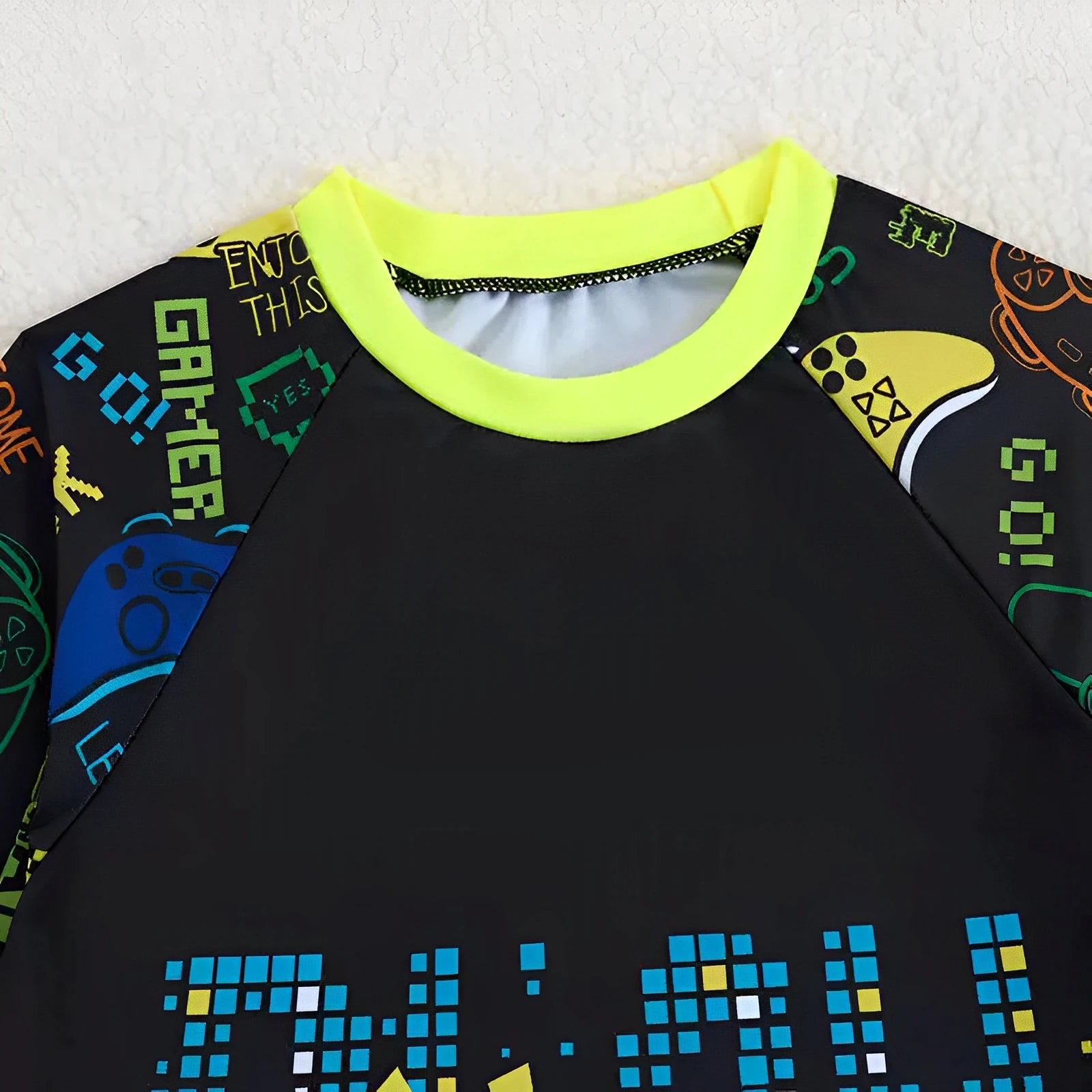 Black shirt with colorful text and graphics on sleeves against a white background