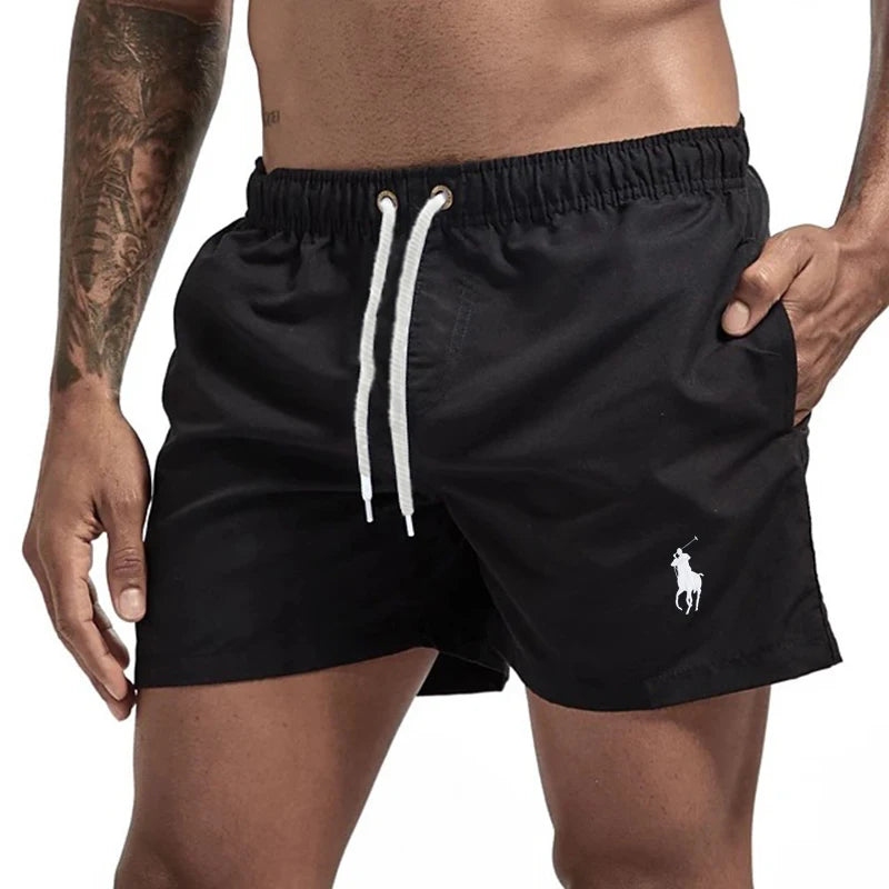 Black swim shorts with a white drawstring and logo on a white background