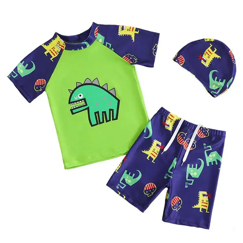 Children's swim set with green rash guard, purple shorts, and matching hat with dinosaur design on a white background.