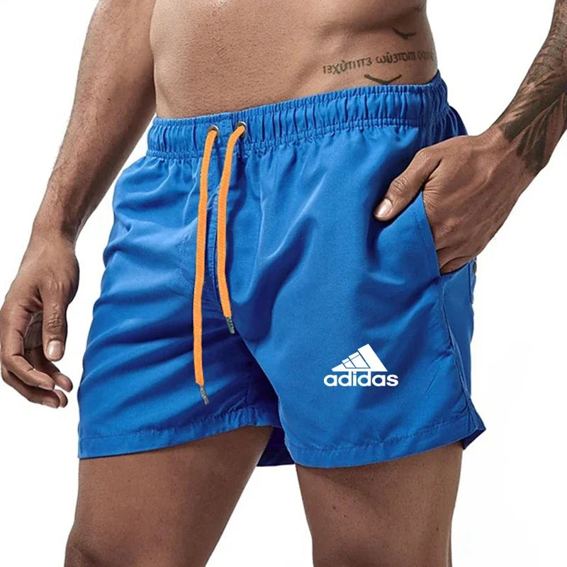 Blue Adidas shorts with orange drawstring on a white background