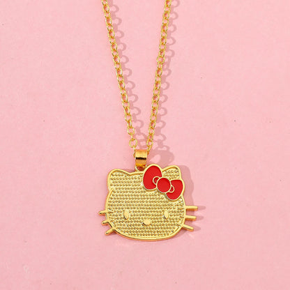 Gold Hello Kitty pendant necklace on a pink background