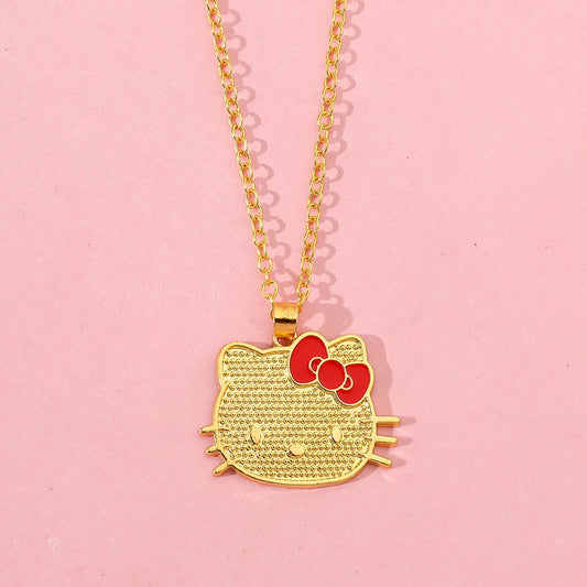 Gold Hello Kitty pendant necklace on a pink background