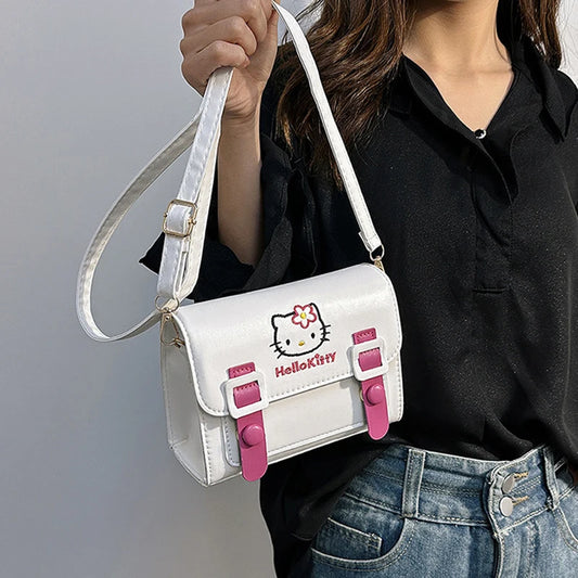 Person holding a white Hello Kitty handbag with pink accents against a gray background