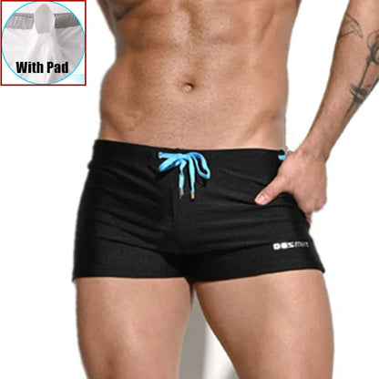 Black swim shorts with blue drawstring on a white background