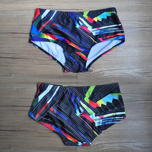 Colorful patterned swim briefs on a wooden floor