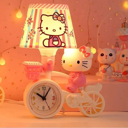 Hello Kitty-themed children's room decor with lamp, clock, and figurines on a pink bicycle.