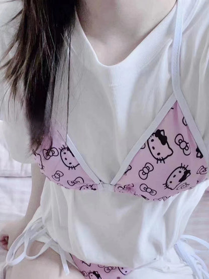 Person wearing a white top with a pink Hello Kitty patterned bra.