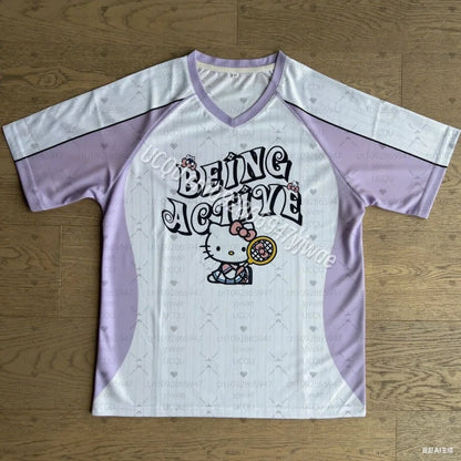 White and purple sports jersey with 'Being Active' text and Hello Kitty graphic on a wooden surface