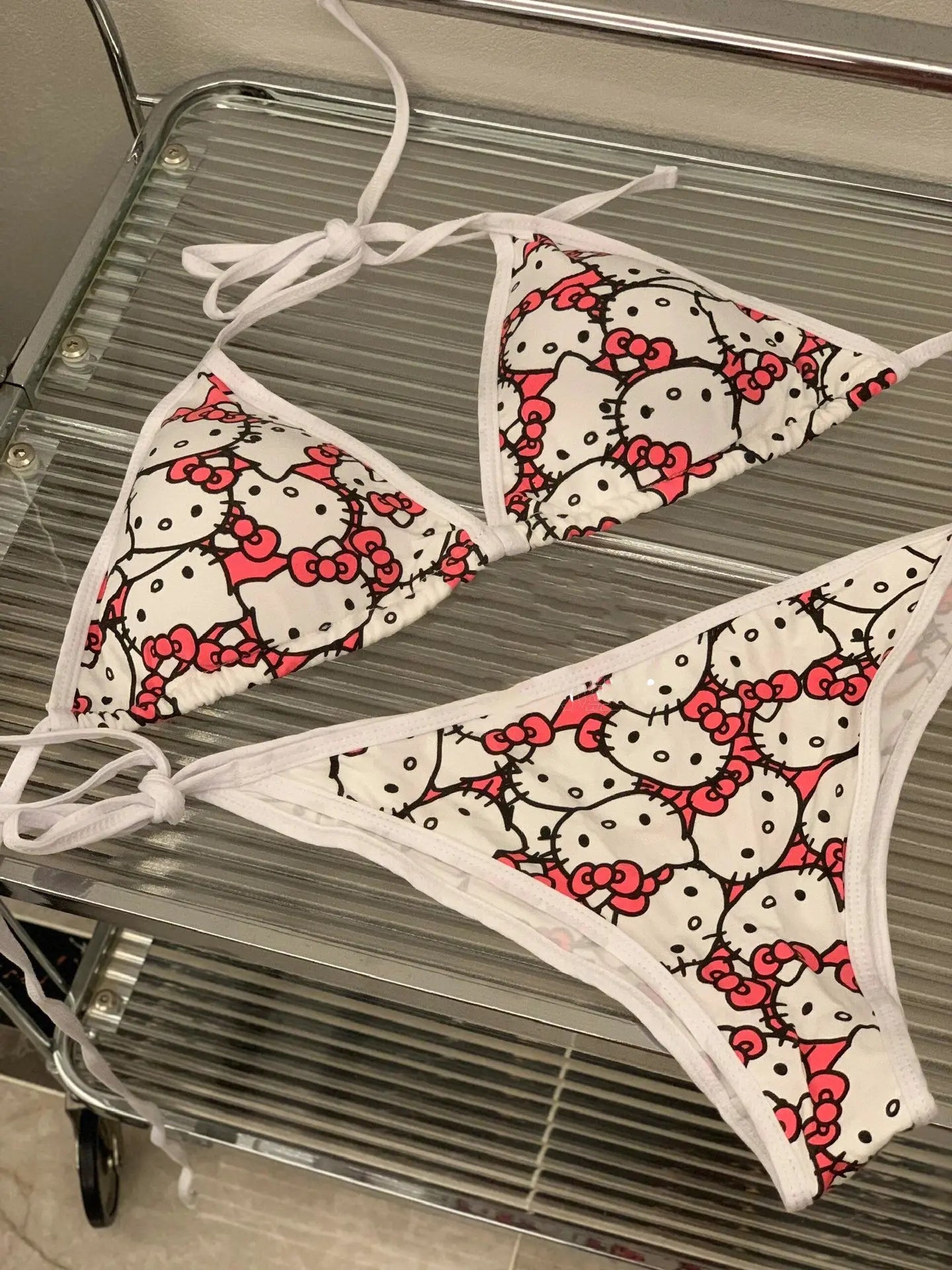 Hello Kitty patterned bikini set on a metal surface