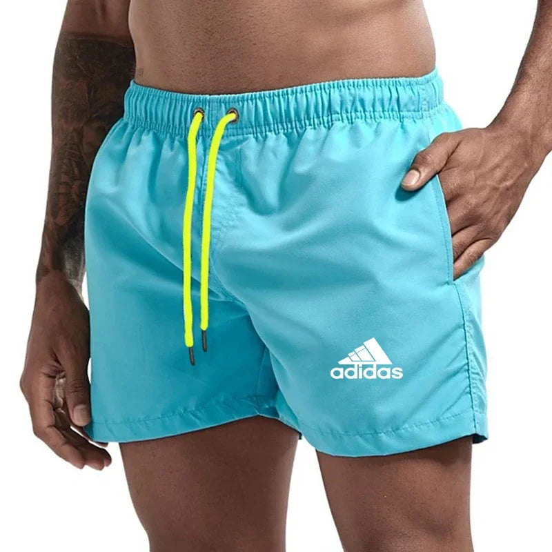 Sky blue Adidas shorts with orange drawstring on a white background