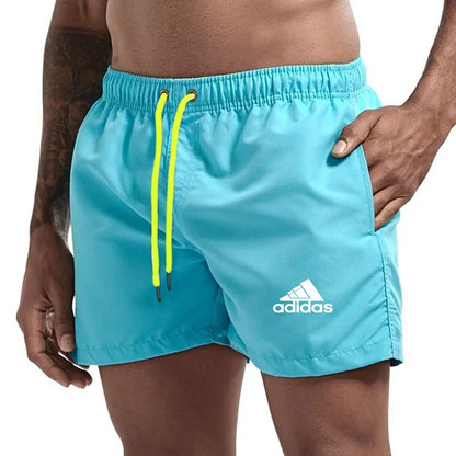 Sky blue Adidas shorts with orange drawstring on a white background