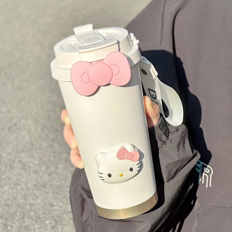 White tumbler with Hello Kitty design held by a person