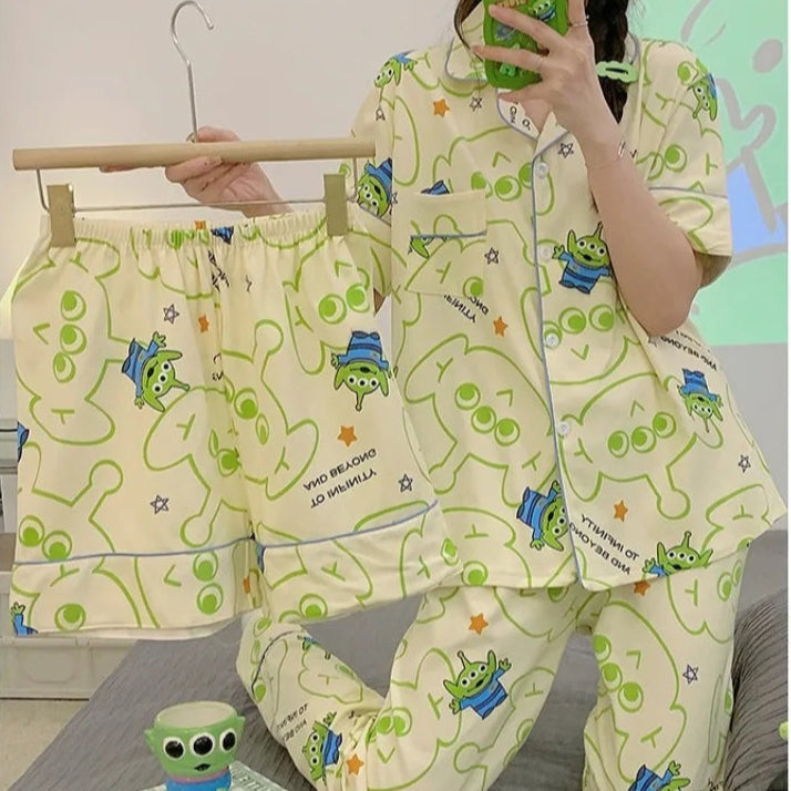 Person wearing a green and white pajama set with cartoon characters, holding a phone.