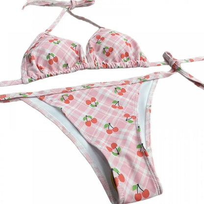Pink bikini set with cherry pattern on a white background
