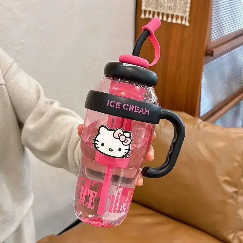 Pink water bottle with Hello Kitty design held by a person indoors.