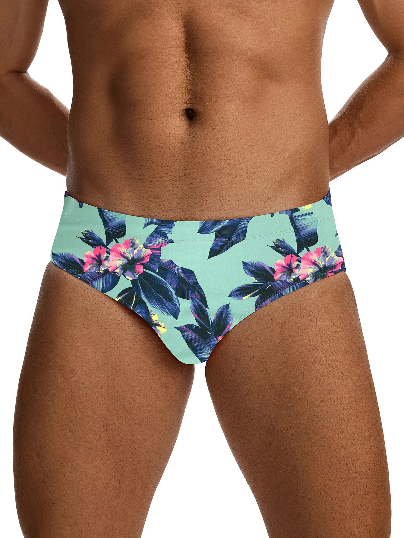 Tropical floral swim briefs worn by a person on a white background