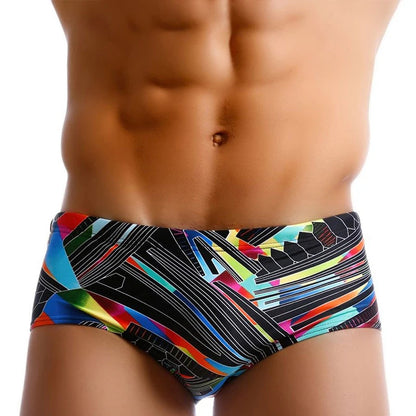 Colorful swim briefs with geometric pattern worn by a person on a white background