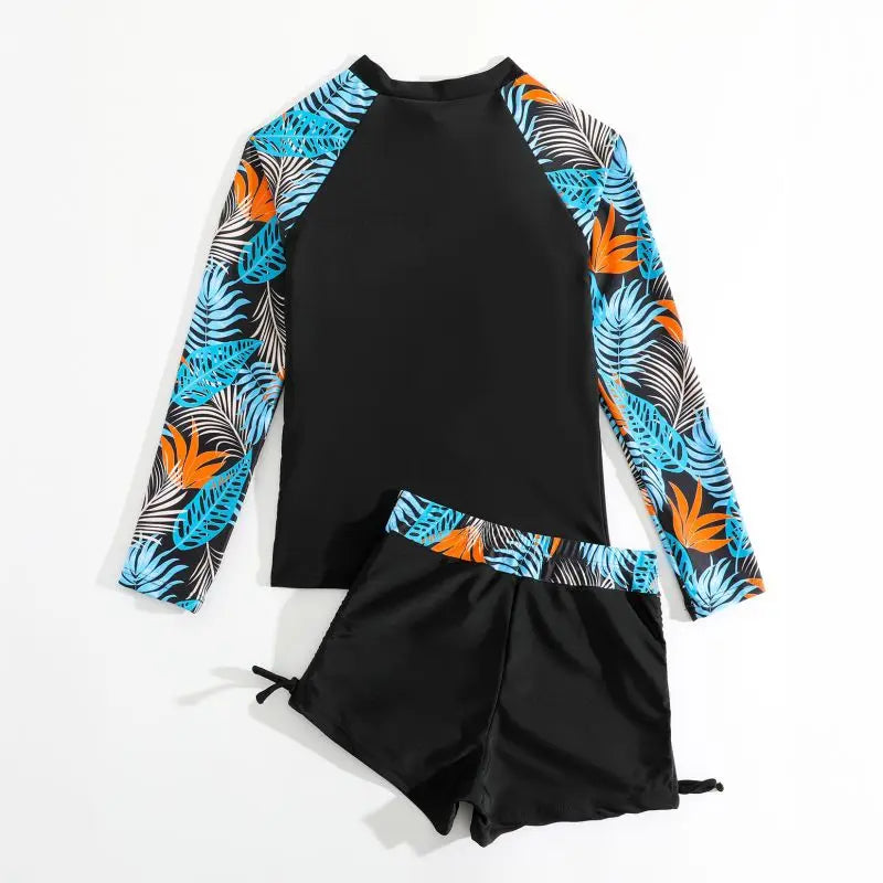 Black and colorful tropical print long-sleeve rash guard and shorts set on a white background
