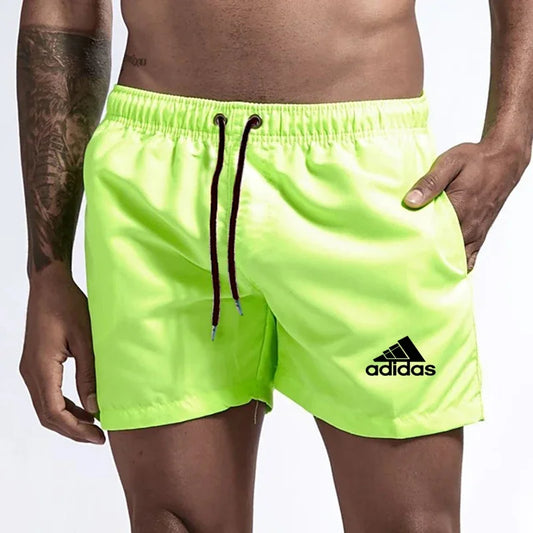 Neon green Adidas shorts worn by a person on a white background