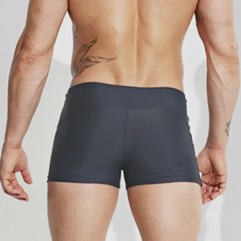 Person wearing black boxer briefs on a plain background