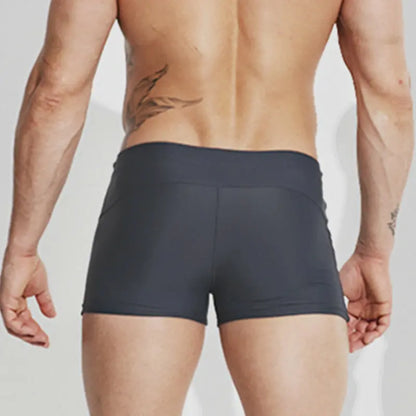 Person wearing black boxer briefs on a plain background