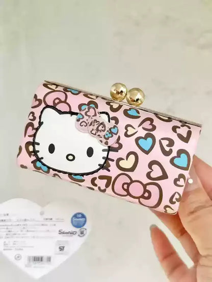 Hello Kitty clutch bag with heart pattern held by a hand on a light background
