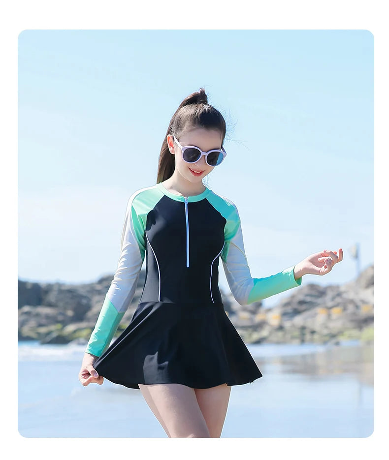 Woman wearing a black and green swimsuit with a scenic background