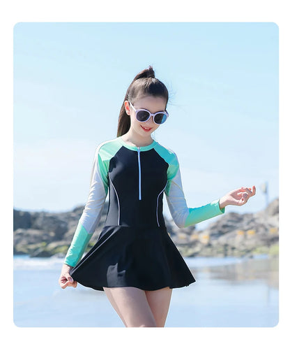 Woman wearing a black and green swimsuit with a scenic background