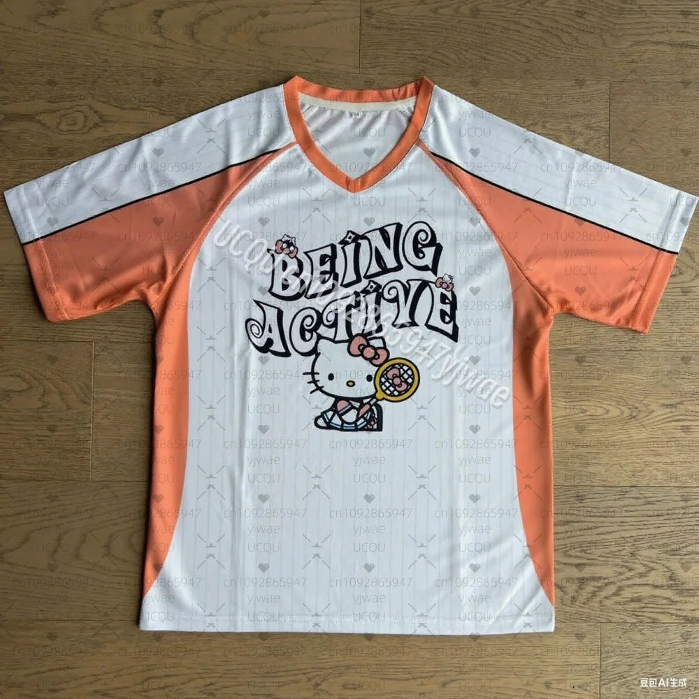 Orange and white t-shirt with Hello Kitty design on a wooden surface