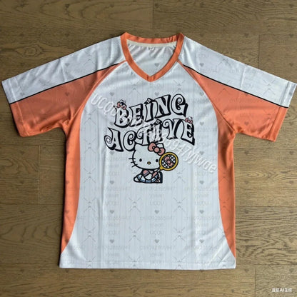 Orange and white t-shirt with Hello Kitty design on a wooden surface