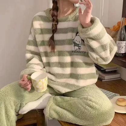 Person wearing a green and white striped pajama set with a cartoon character, holding a cup.