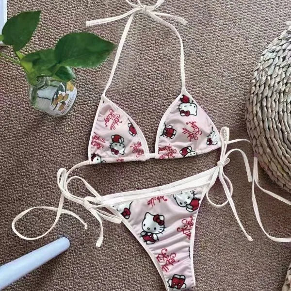 Hello Kitty bikini set on a textured surface with a plant and basket in the background