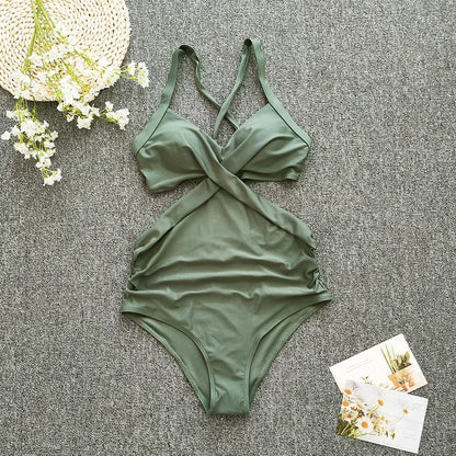 Green swimsuit on a textured surface with flowers and cards.