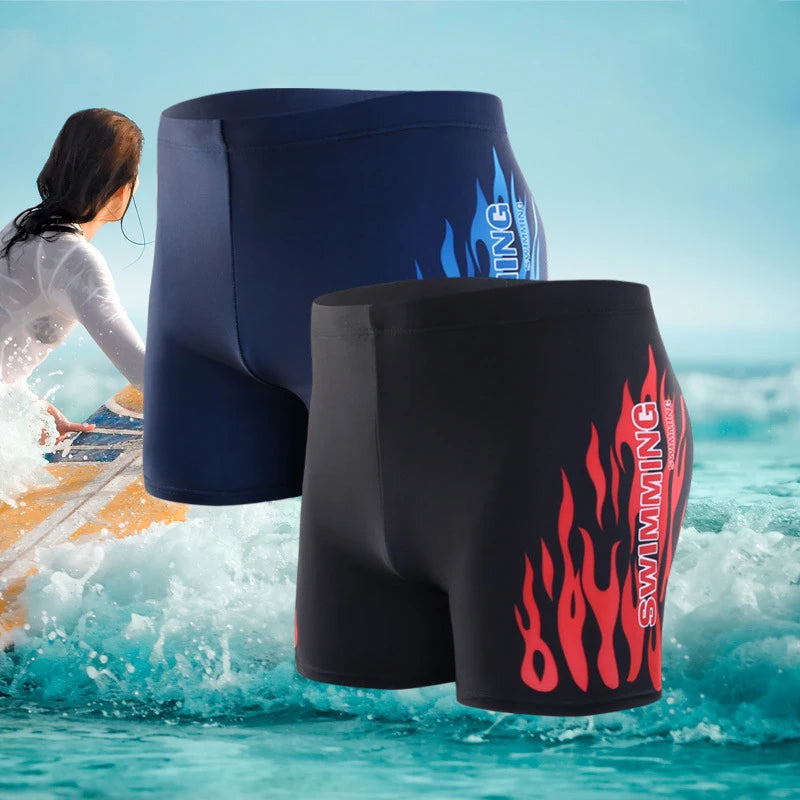 Two pairs of swim shorts with flame designs on a beach background