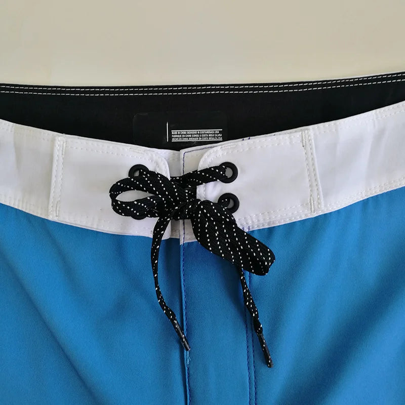 Close-up of blue shorts with a black waistband and decorative bow.